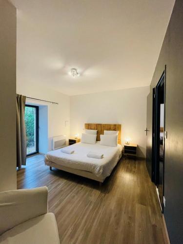 une chambre avec un lit avec des draps blancs et des oreillers dans l'établissement Domaine-Charme-Piscine-Domme, à Domme