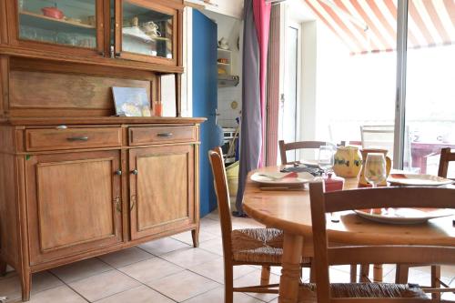 une salle à manger avec une table et une grande armoire en bois dans l'établissement Appartement 2 pièces - Gruissan GN580-028, à Gruissan