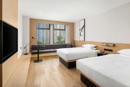 a hotel room with two beds and a flat screen tv at Fairfield by Marriott Hangzhou Qiantang in Hangzhou
