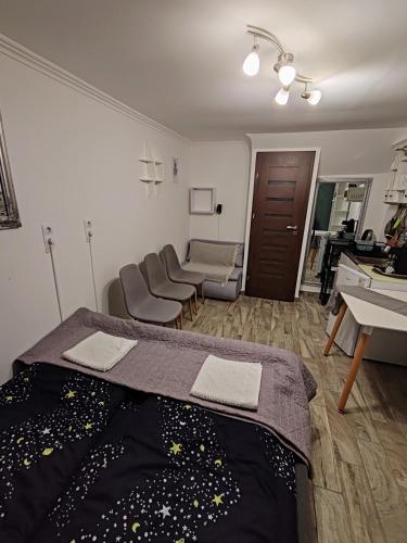 a room with a bed and chairs in it at Silver Apartments in Bogács