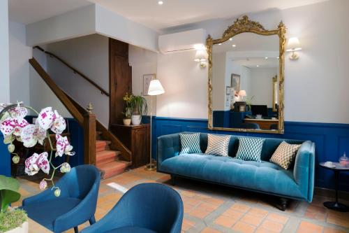 a living room with a blue couch and a mirror at Hotel Mogador in Paris