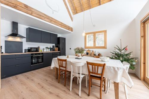 une cuisine et une salle à manger avec une table et des chaises blanches dans l'établissement La grange de Fernande - 8 personnes, à Jarsy