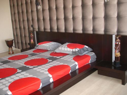 Bett mit einer roten und grauen Bettdecke und Kissen in der Unterkunft Most City Premium apartments in Dnipro