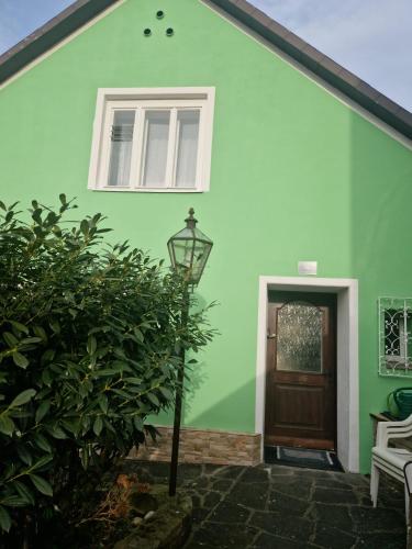 a green house with a door and a lamp at Appartment Lidia in Marbach an der Donau