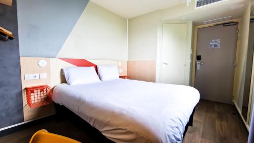 a bedroom with a large white bed and a chair at ibis Budget Lille Marcq En Baroeul in Marcq-en-Baroeul