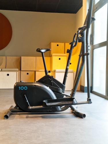 an exercise bike in a room with boxes at ibis Budget Lille Marcq En Baroeul in Marcq-en-Baroeul