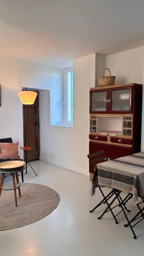 un salon avec une table et une chaise dans l'établissement Oléron MaisonMer, au Château-dʼOléron