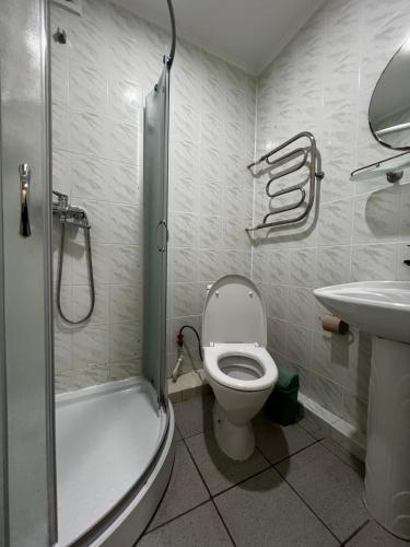 a bathroom with a toilet and a sink and a shower at Готельно-ресторанний комплекс Поділля in Bershadʼ