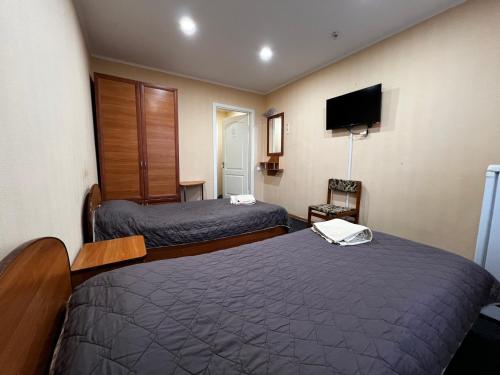 a hotel room with two beds and a flat screen tv at Готельно-ресторанний комплекс Поділля in Bershadʼ