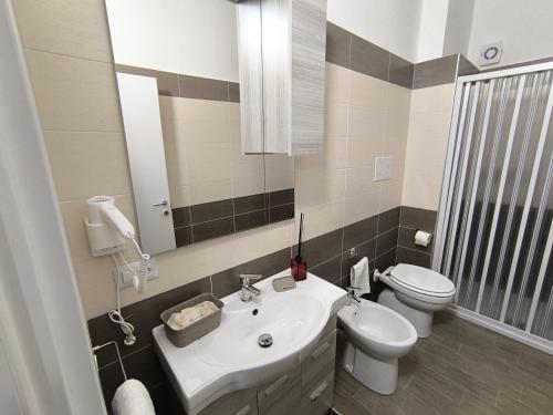a bathroom with a sink and a toilet and a mirror at Affittacamere dragone in Cimitile
