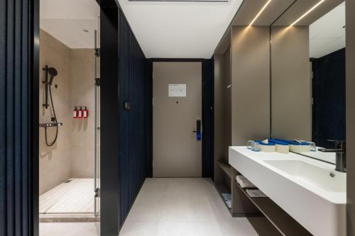 a bathroom with two sinks and a shower at Atour Hotel Wuxi Meili Ancient Town Jinglong Plaza in Wuxi