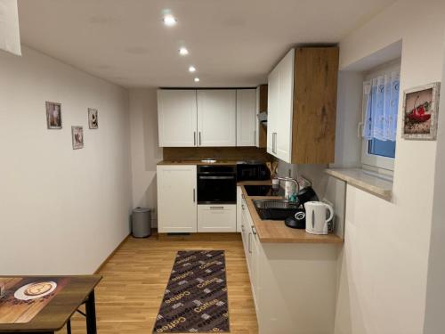 a small kitchen with white cabinets and a table at Graf in Oberigling