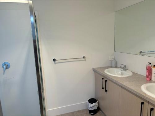 a bathroom with a shower and a sink and a mirror at Sunflower Homes- Light and Easy in Munno para Downs