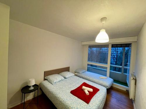 a bedroom with two beds and a window at BnGo I Le Spacieux I 12 personnes, 5 chambres, 2 salle de bain, parking privé, WC séparé, Wifi in Villeurbanne