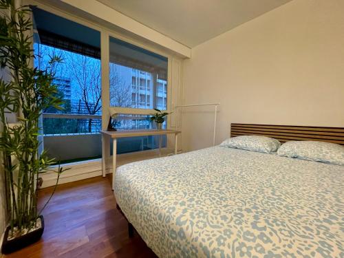 a bedroom with a bed and a large window at BnGo I Le Spacieux I 12 personnes, 5 chambres, 2 salle de bain, parking privé, WC séparé, Wifi in Villeurbanne
