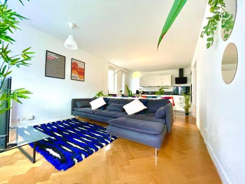 a living room with a couch and a blue rug at BnGo I Le Spacieux I 12 personnes, 5 chambres, 2 salle de bain, parking privé, WC séparé, Wifi in Villeurbanne