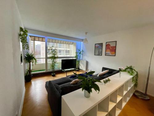 a living room with a couch and a table at BnGo I Le Spacieux I 12 personnes, 5 chambres, 2 salle de bain, parking privé, WC séparé, Wifi in Villeurbanne