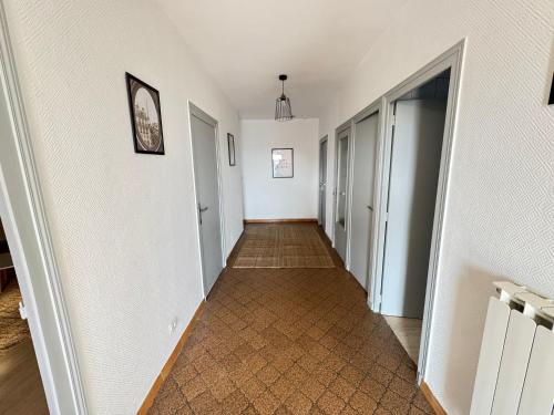 a hallway with white walls and a tile floor at 120m T4 terrasse et parking - Stade-Eurexpo-Lyon in Meyzieu