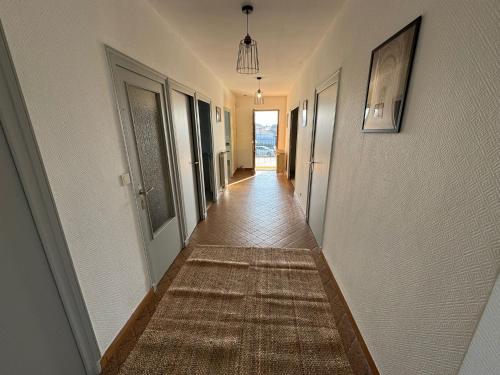 a hallway with a rug on the floor of a house at 120m T4 terrasse et parking - Stade-Eurexpo-Lyon in Meyzieu
