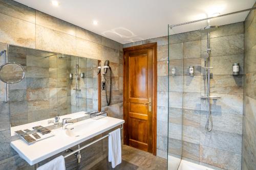 a bathroom with a sink and a shower at Abba Xalet Suites Hotel in Sispony
