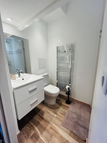 une salle de bain blanche avec des toilettes et un lavabo dans l'établissement Comfy Loft - Dalby, à Nantes