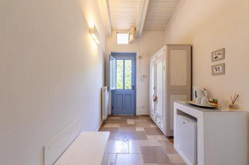 a kitchen with a blue door and a tile floor at Masseria La Tofala benessere & SPA in Copertino
