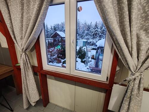 a window with a view of a snow covered yard at Silver Apartments in Bogács