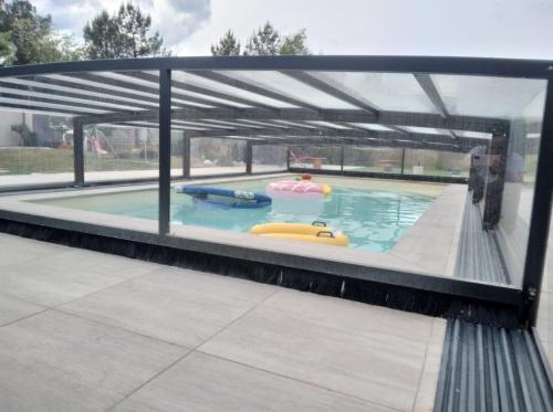 a large swimming pool with two inflatables in it at Gîte à la campagne 4 in Cérans-Foulletourte
