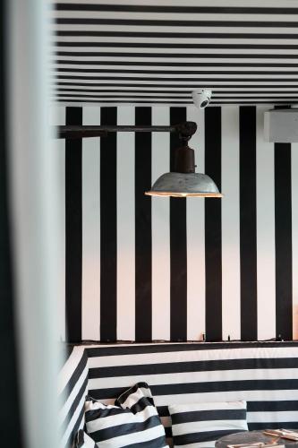 a bed with a black and white striped wall at O Petit Monde in Sanary-sur-Mer