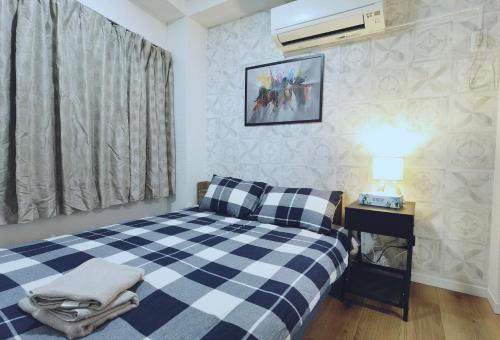 a bedroom with a blue and white checkered bed at #303WZNET梅屋敷駅2分横浜羽田空港都心便利商店街1ldk広い in Tokyo