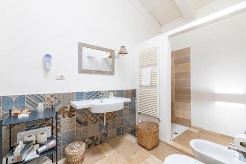 a bathroom with a sink and a toilet at Masseria La Tofala benessere & SPA in Copertino