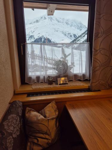 a view of a snow covered mountain from a window at Schusslerhof in Sankt Leonhard im Pitztal