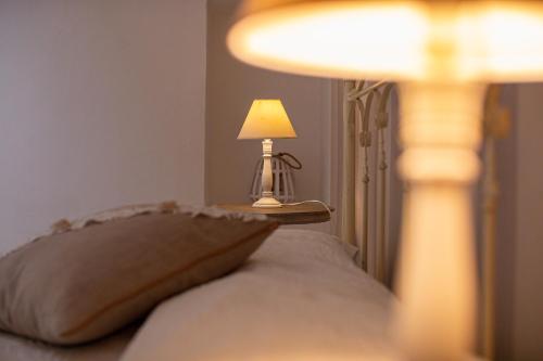 a bed with a pillow and a lamp on a table at Masseria La Tofala benessere & SPA in Copertino