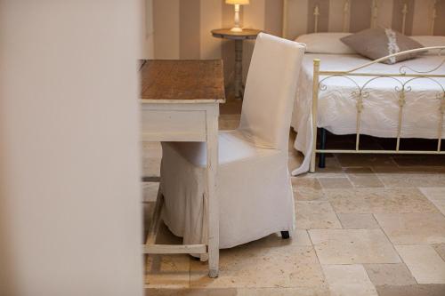 a desk with a chair next to a bed at Masseria La Tofala benessere & SPA in Copertino