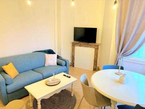 a living room with a blue couch and a table at Appartement cosy au cœur de Saint Quentin in Saint-Quentin