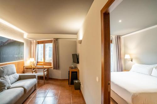 a hotel room with a bed and a couch at Abba Xalet Suites Hotel in Sispony