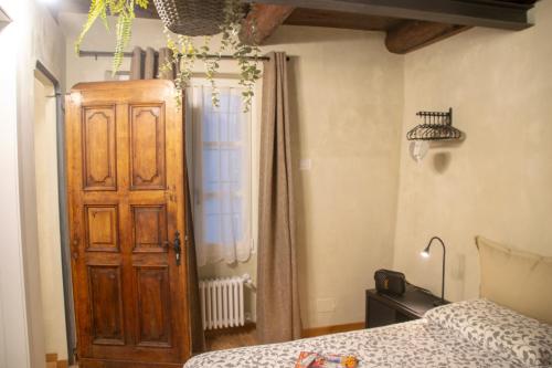 a bedroom with a bed and a wooden door at Casa Rivaest WelcHome in Cannobio
