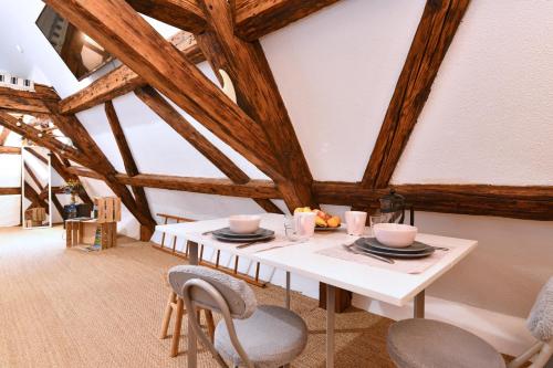 une salle à manger avec une table et des chaises blanches dans l'établissement Gite See You Soon - Studio Surf, à Colmar