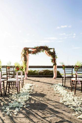 an aisle with chairs and an arch with flowers at Waikoloa Beach Marriott Resort & Spa in Waikoloa