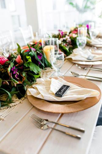 a table with plates and glasses and flowers on it at Waikoloa Beach Marriott Resort & Spa in Waikoloa