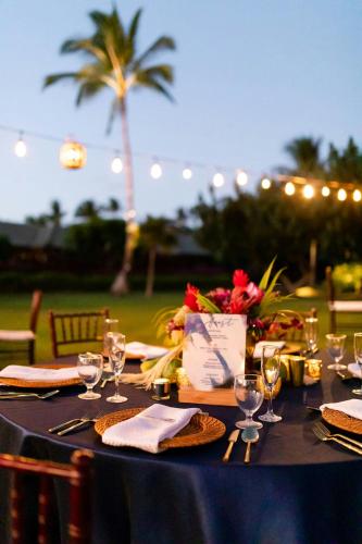 a table with a blue table cloth and wine glasses at Waikoloa Beach Marriott Resort & Spa in Waikoloa