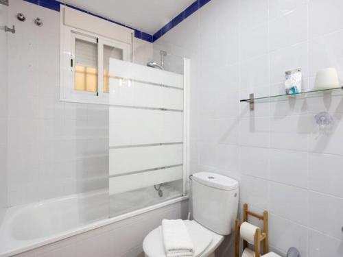Un baño blanco con inodoro y ducha. en Arrecife Home by Staycare, en Rota