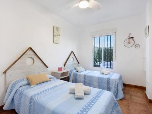 Un dormitorio con dos camas y una ventana. en Arrecife Home by Staycare, en Rota