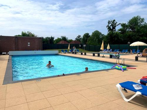a group of people swimming in a swimming pool at Villa Present - Vakantiewoning Herkingen in Herkingen