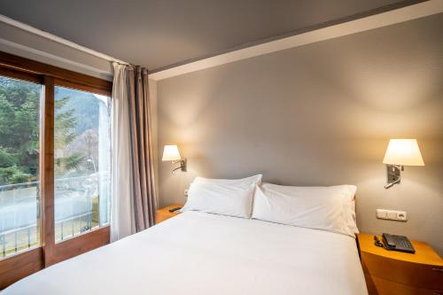 a bedroom with a large bed and a window at Abba Xalet Suites Hotel in Sispony