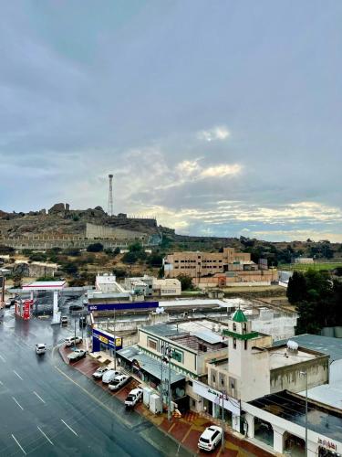 a city with cars parked in a parking lot at فندق قمم بارك Qimam Park Hotel 6 in Al Namas