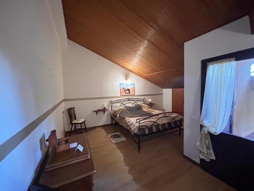 a bedroom with a bed and a wooden ceiling at Tenuta I Ginepri in Ozzano dell'Emilia