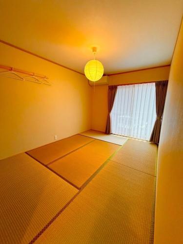 an empty room with a large window and a light at 下呂スプリングスロッジ in Gero