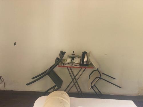 a table with a tea kettle on it in a room at Aeropark Residencial (B&B) in Maputo