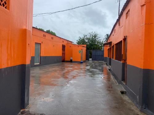 an empty courtyard of a building with orange walls at Aeropark Residencial (B&B) in Maputo